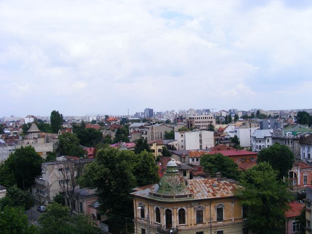 Panoramă urbană cu clădiri istorice și acoperișuri, văzută de la înălțime.