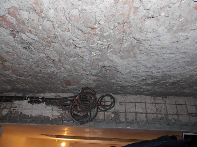 Plafon cu tencuială degradată și porțiuni de plasă metalică vizibile.