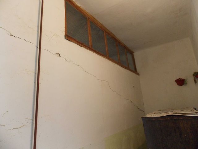 Perete tencuit cu fisură oblică ce traversează suprafața.